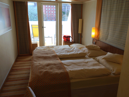 Balkonkabine auf AIDAluna Blick über das Doppelbett zum Balkon.