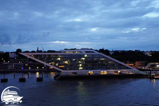 Blick vom Schiff auf das Dockland Gebäude am Abend.