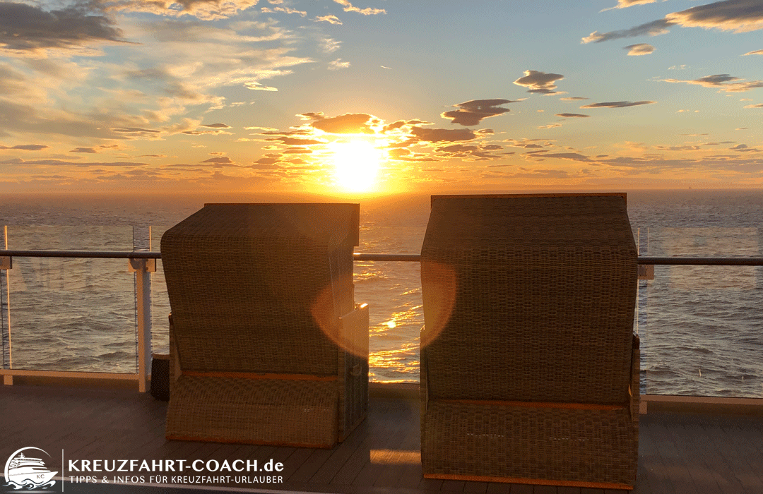 Blick über die Strandkörbe an Bord in den Sonnenuntergang.